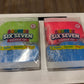 Two packages of Squeeze Six Seven Squeeze Toys, one with blue and green packaging and the other with blue and pink packaging, wrapped in clear plastic on a white surface.