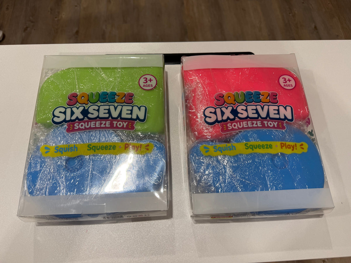 Two packages of Squeeze Six Seven Squeeze Toys, one with blue and green packaging and the other with blue and pink packaging, wrapped in clear plastic on a white surface.